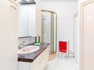 a bathroom with a sink and a shower and a red chair at Apartment L'écluse-2 by Interhome in Dinard