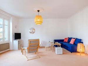 a living room with a blue couch and a table at Apartment L'écluse-2 by Interhome in Dinard