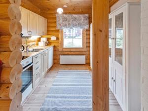 a kitchen with white cabinets and a blue rug at Holiday Home Lompakko by Interhome in Äkäslompolo