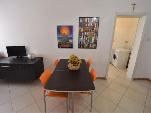 a dining room with a black table and orange chairs at Apartment Rosapanna-2 by Interhome in Rosapineta