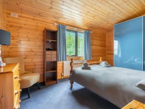 sypialnia z łóżkiem, biurkiem i krzesłem w obiekcie Chalet Lodge 9 by Interhome w mieście Kinross