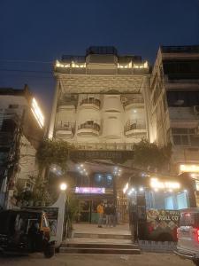 um edifício com pessoas à frente dele à noite em Hotel Padmini International- Sigra em Kakarmatha