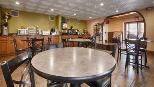 um restaurante com mesas e cadeiras e um bar em Baymont by Wyndham Goodlettsville Nashville em Goodlettsville
