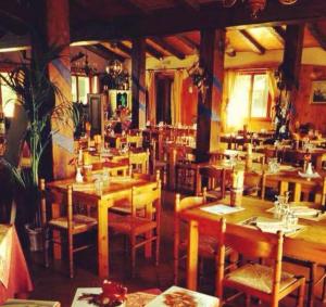 un restaurante con mesas de madera y sillas en una habitación en Villa Eleonora en Piteglio