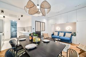 comedor y sala de estar con mesa y sillas en Splendide appartement pour 6 proche Montmartre en París