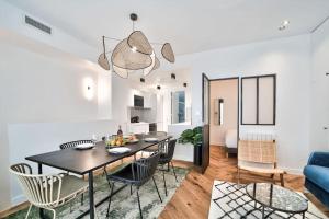 een eetkamer en een woonkamer met een tafel en stoelen bij Splendide appartement pour 6 proche Montmartre in Parijs