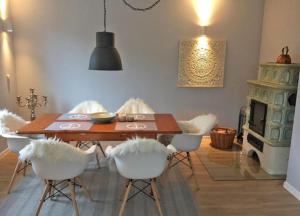 a dining room with a wooden table and white chairs at Ferienhaus Cozy Cottage 1 in Neue Tiefe Fehmarn