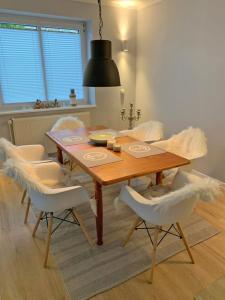 a dining room table with white chairs around it at Ferienhaus Cozy Cottage 1 in Neue Tiefe Fehmarn