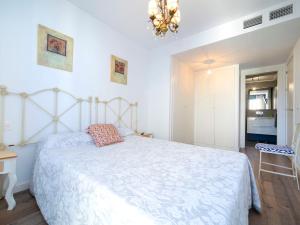 a bedroom with a white bed and a chandelier at Apartment Isea Calpe-5 by Interhome in Calpe