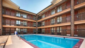 a building with a swimming pool in front of a building at Baymont by Wyndham Goodlettsville Nashville in Goodlettsville