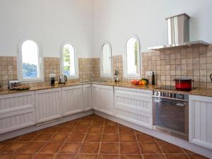 cocina con armarios blancos y suelo de baldosa en Villa El Paraiso al Mar Ambolo by Interhome, en Jávea