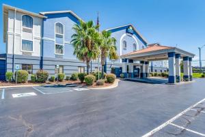 a building with a parking lot in front of it at Days Inn & Suites by Wyndham Prattville-Montgomery in Prattville
