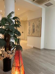 a room with a plant and a painting on the wall at Hotel La Mota - BGA Hoteles in Medina del Campo