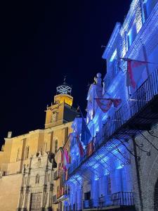 un bâtiment doté de lumières bleues et d'une tour d'horloge. dans l'établissement Hotel La Mota - BGA Hoteles, à Medina del Campo
