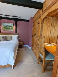 a bedroom with a bed and a wooden wall at Whittakers Barn Farm Bed and Breakfast in Cracoe