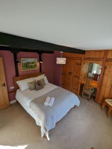 a bedroom with a large bed with two slippers on it at Whittakers Barn Farm Bed and Breakfast in Cracoe