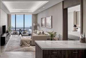 a kitchen and living room with a couch and a table at Ashta Residence in Jakarta