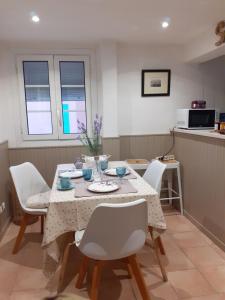 a dining room with a table and white chairs at BANDOL: ÉLÉGANT et COSY 2 PIÈCES, PROCHE VILLE et PLAGE in Bandol