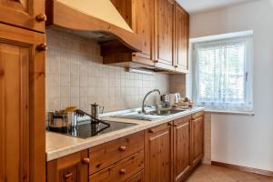 a kitchen with wooden cabinets and a sink at Betites Trilocale in Canazei