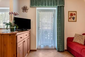 a living room with a television and a red couch at Betites Trilocale in Canazei