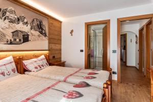 a bedroom with two beds and a mirror at Betites Trilocale in Canazei