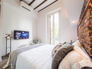 1 dormitorio con cama y pared de ladrillo en Emma's home Monza, en Monza