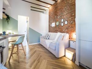 een woonkamer met een bank en een bakstenen muur bij Emma's home Monza in Monza