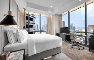 a bedroom with a bed and a desk with a computer at Ashta Residence in Jakarta