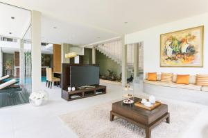 a living room with a television and a table at Uga Bay - Pasikuda in Pasikuda