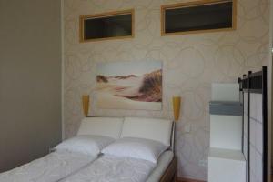 ラウターバッハにあるUrlaubsbahnhof-Stellwerkのベッドルーム1室(壁に2枚の写真が飾られたベッド1台付)