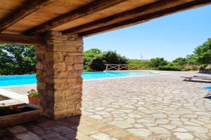 um pátio de pedra com uma piscina e uma pérgola de madeira em Chalet In Enchanted Forest Private Pool - Happy Rentals em Baschi