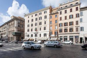 una strada di città con auto parcheggiate di fronte agli edifici di Amazing Vittoriano a Roma