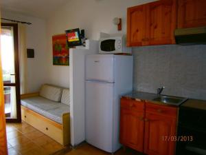 eine Küche mit einem weißen Kühlschrank und einer Mikrowelle in der Unterkunft Casa Michela in Torre Dei Corsari