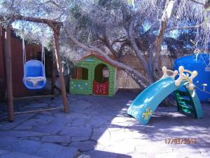 einen Spielplatz mit Rutsche und Spielhaus in der Unterkunft Casa Michela in Torre Dei Corsari