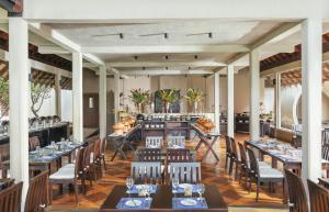 une salle à manger avec de longues tables et chaises dans l'établissement Uga Bay - Pasikuda, à Pasikuda