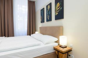 1 dormitorio con 1 cama y 1 mesa con lámpara en Vienna Stay Apartments Pezzl 1170 en Viena