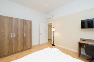 a living room with wooden cabinets and a tv at Vienna Stay Apartments Pezzl 1170 in Vienna
