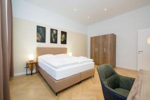 sypialnia z łóżkiem i krzesłem w obiekcie Vienna Stay Apartments Pezzl 1170 w Wiedniu