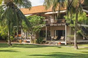 a house with palm trees in front of it at Uga Bay - Pasikuda in Pasikuda