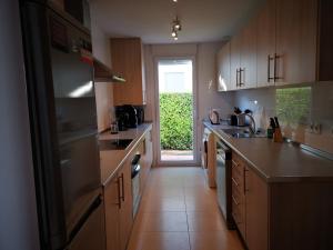 een keuken met houten kasten en een grote koelkast bij Condado de Alhama Golf resort - Villa Alba in Alhama de Murcia