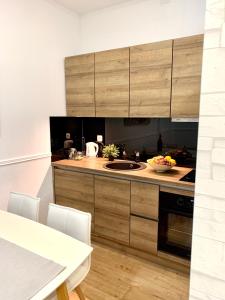 a kitchen with wooden cabinets and a white table with chairs at Croatia_Zagreb Apartment in Zagreb