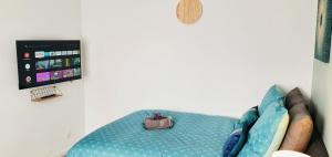 a room with a couch with a television and a bag at The Sky - Dormez sur un petit nuage in Dreux