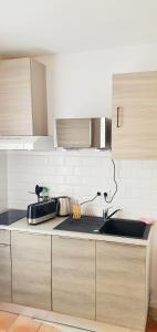 a kitchen with a sink and a counter top at The Sky - Dormez sur un petit nuage in Dreux