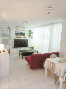 a living room with a red couch and a table at HABITACION EN CHUECA, CENTRO DE MADRID in Madrid
