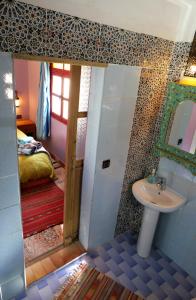 1 dormitorio con 1 cama y baño con lavabo. en Zaratoustra en Imlil