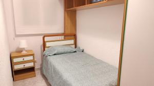 een kleine slaapkamer met een bed en een spiegel bij Apartamento Cristina in Madrid