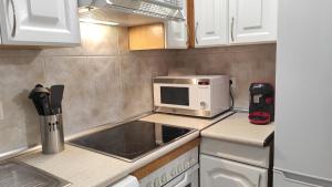 een keuken met een magnetron en een fornuis top oven bij Apartamento Cristina in Madrid