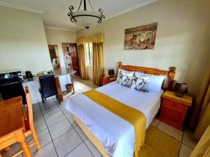 a bedroom with a large bed and a kitchen at Resthaven Guesthouse in Matatiele