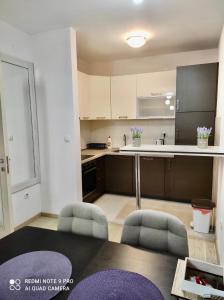 a kitchen with a table and chairs in a room at Apartment City Kvart Podgorica in Podgorica