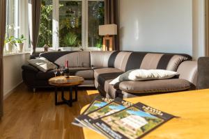 uma sala de estar com um sofá e uma mesa em Traum-Ferienwohnungen Georgenthal em Georgenthal